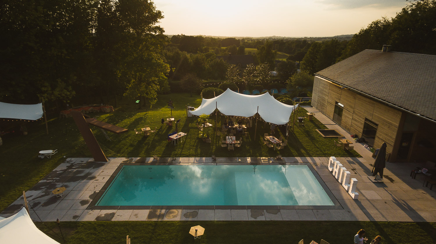 Vue aérienne d’une tente stretch blanche installée pour une réception privée en extérieur