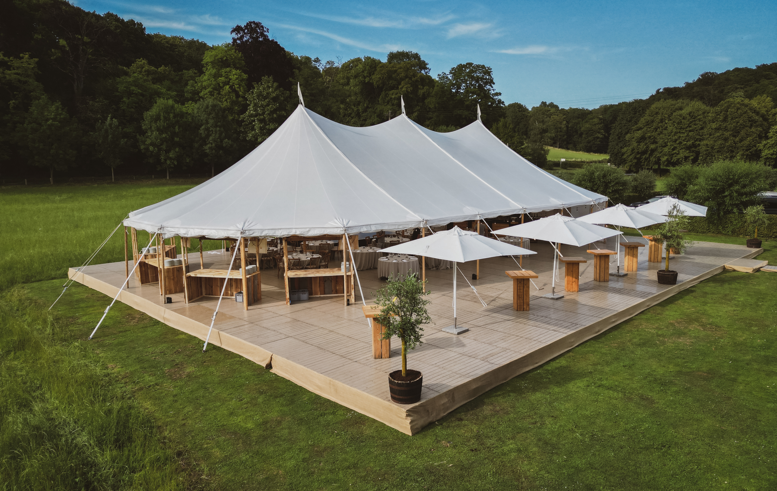 Vue aérienne d’une grande tente événementielle blanche installée pour une réception en extérieur