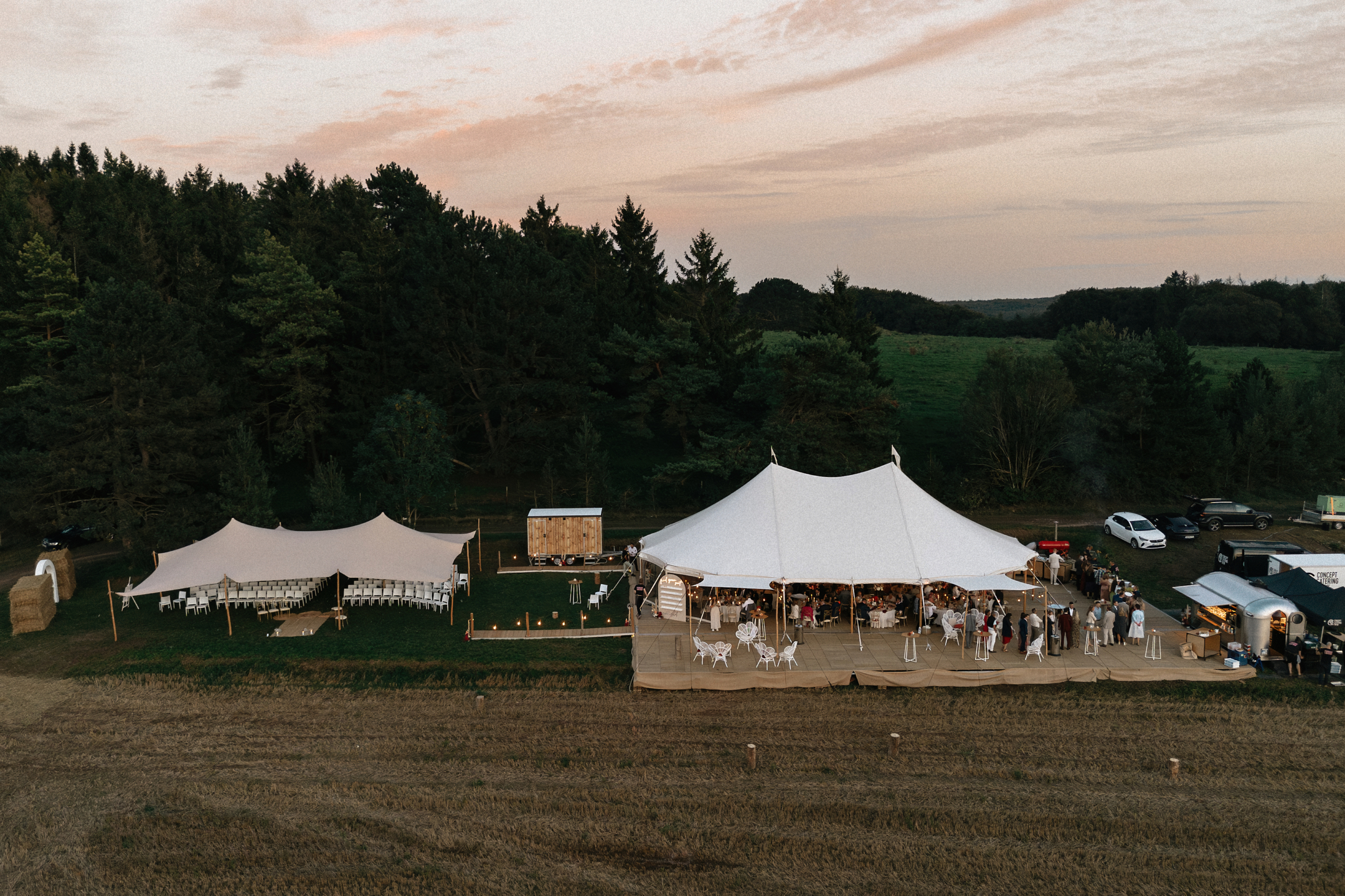 Vue aérienne de tentes événementielles blanches installées pour un mariage en plein air