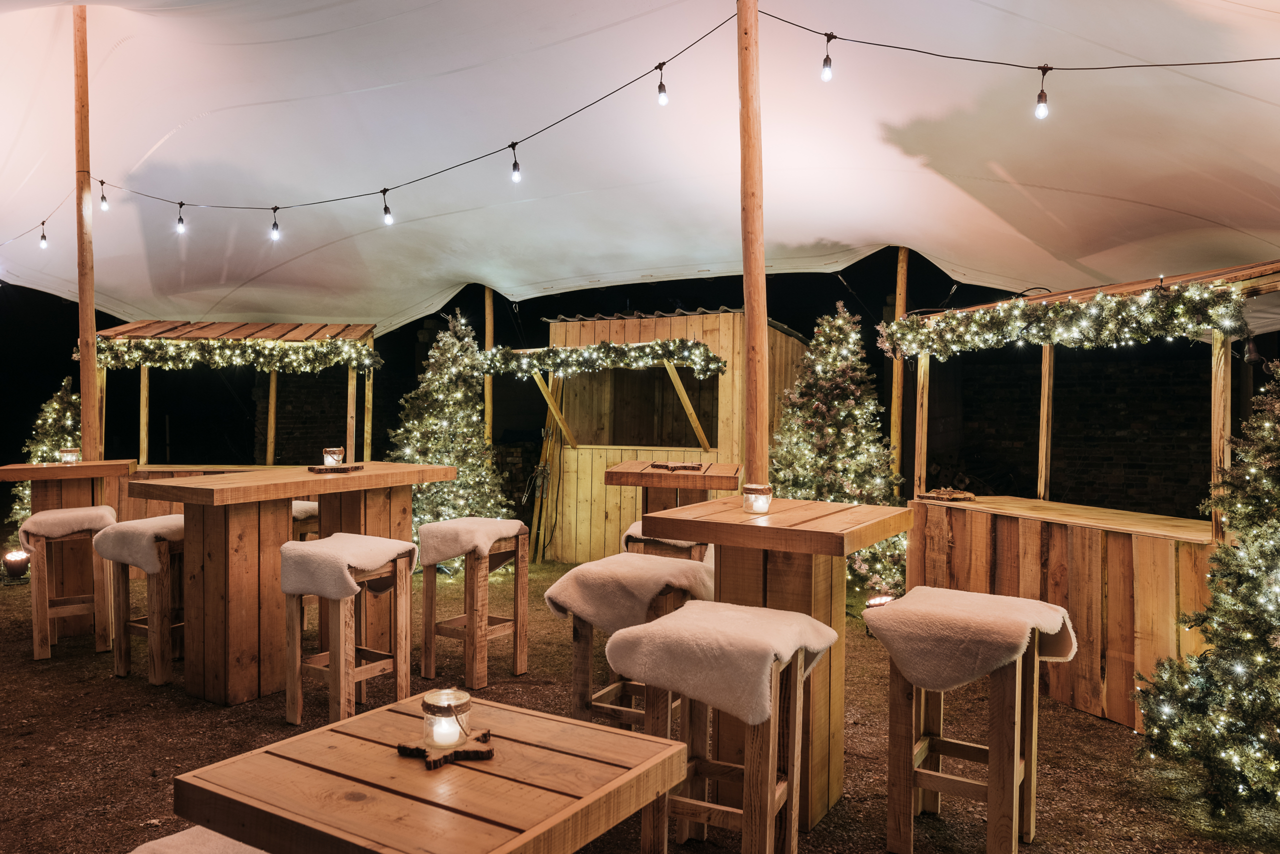 Tente stretch pour marché de Noël avec chalets en bois et éclairage chaleureux